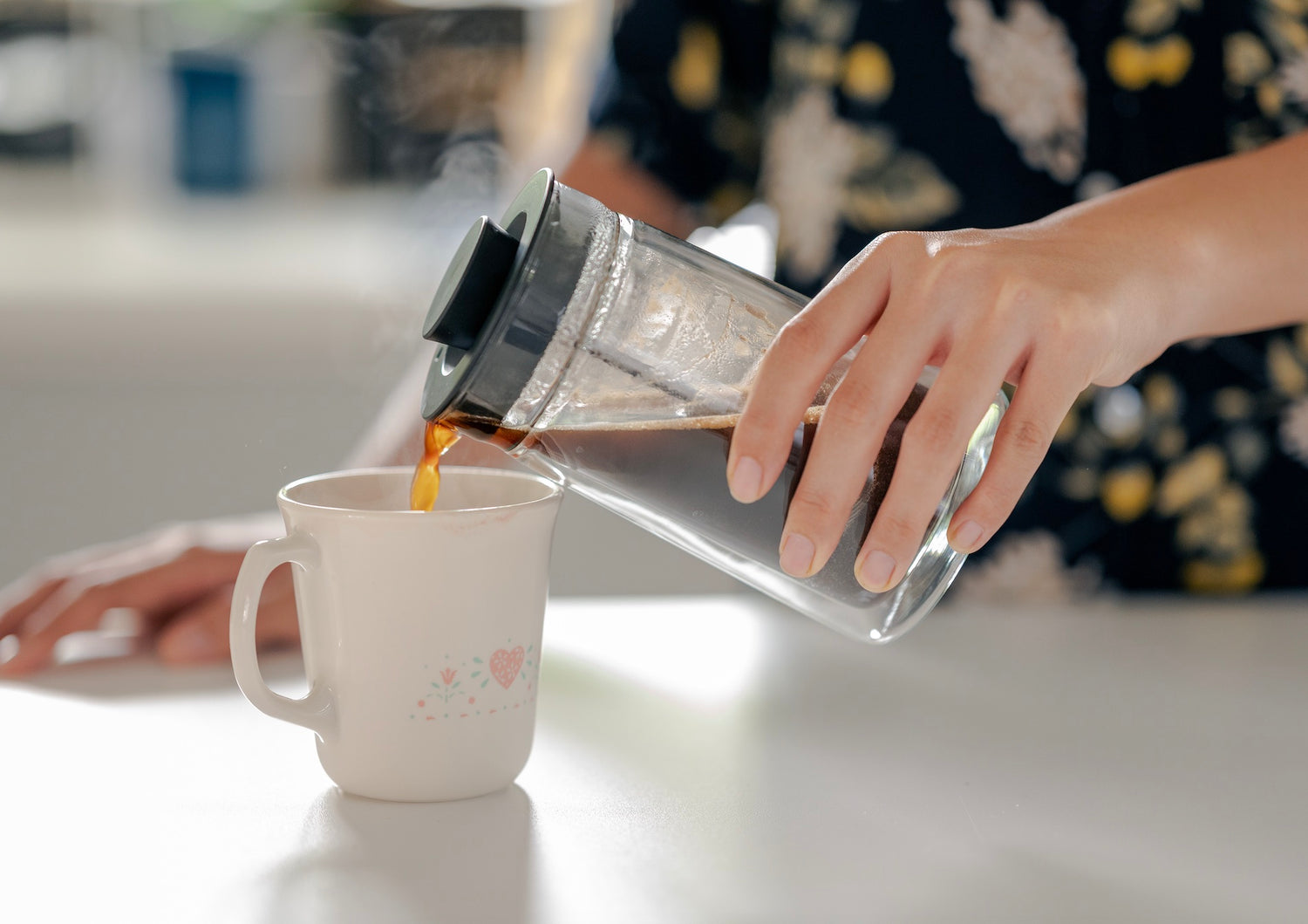 Cup of filter cacao in front of french press